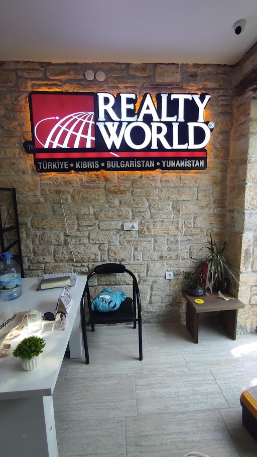 Realty World Elit Gayrimenkul Yeni Foça ofisinde ışıklı kutu harf tabela